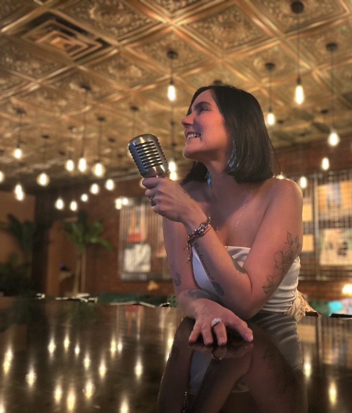 Mau Garcerant performing with a vintage microphone at a Charlotte, NC venue